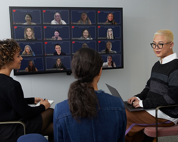 Three people in a room on a video conference